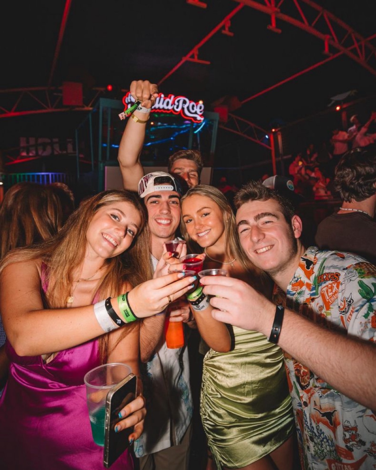 Group of friends toasting shots together at El Squid Roe in downtown Cabo San Lucas